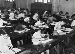 English: School children doing exams inside a ... English: School children doing exams inside a ...